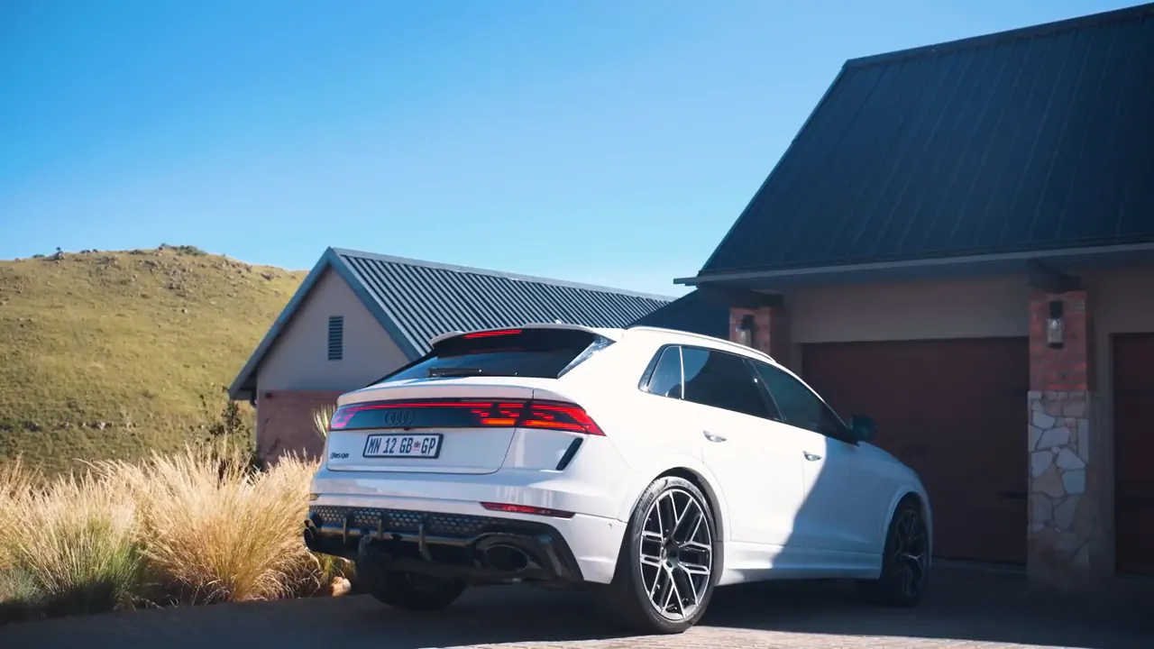 White Audi RSQ8 seen from behind outside a house with a dark roof
