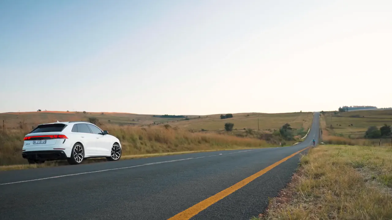 White Audi RSQ8 parked on the verge of an empty highland road