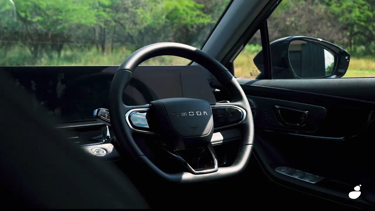 Steering wheel of the Omoda C5 seen through the open driver's door