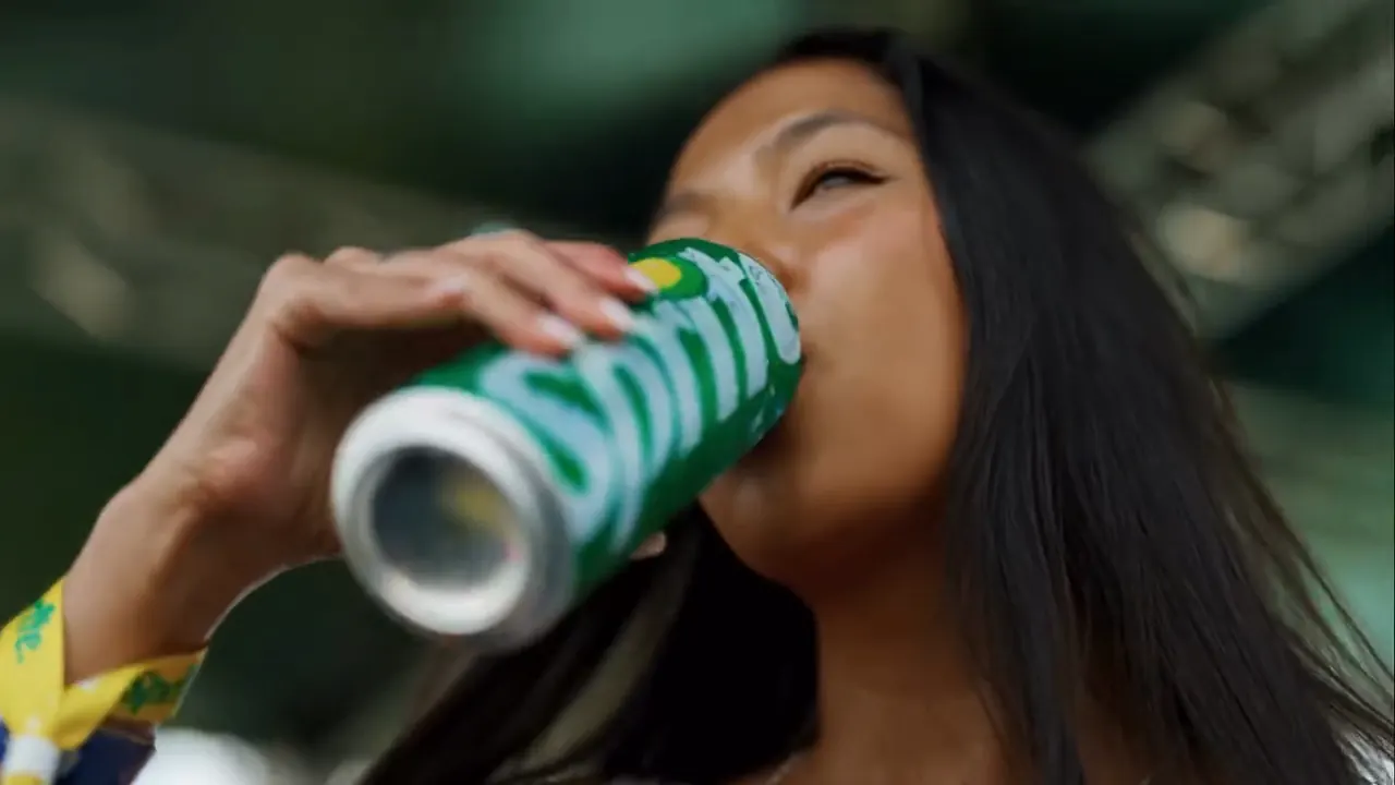 Festival-goer drinking from a Sprite can, shot from below