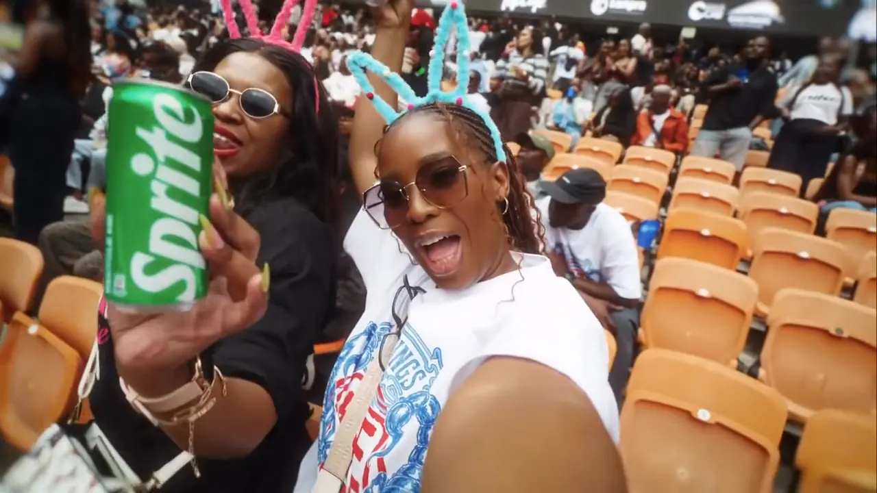 Fans in bunny ears holding up a Sprite can in the stadium stands
